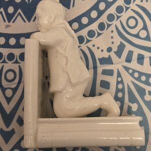 Bookend white ceramic unmarked of a boy kneeling on huge books with braid vintag